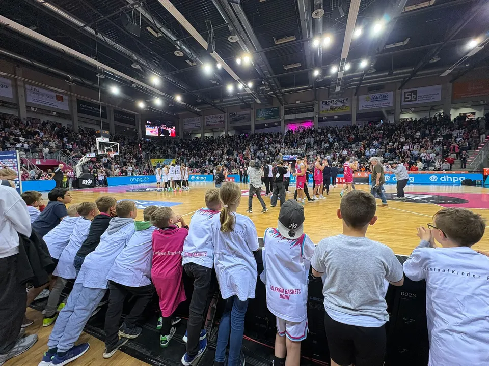 Volle Ränge im Telekom Dome, davor die Kinder der F-Jugend an der Bande