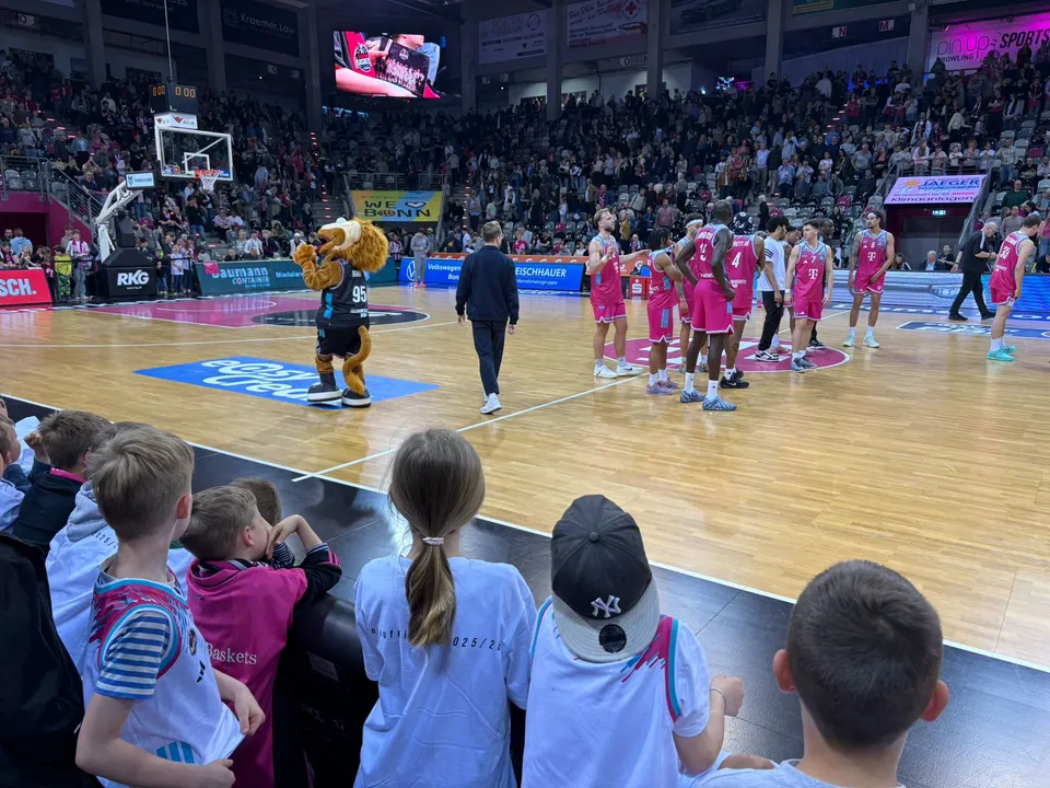 Blick auf das Spielfeld im Telekom Dome mit Spielern der Telekom Baskets und dem Maskottchen